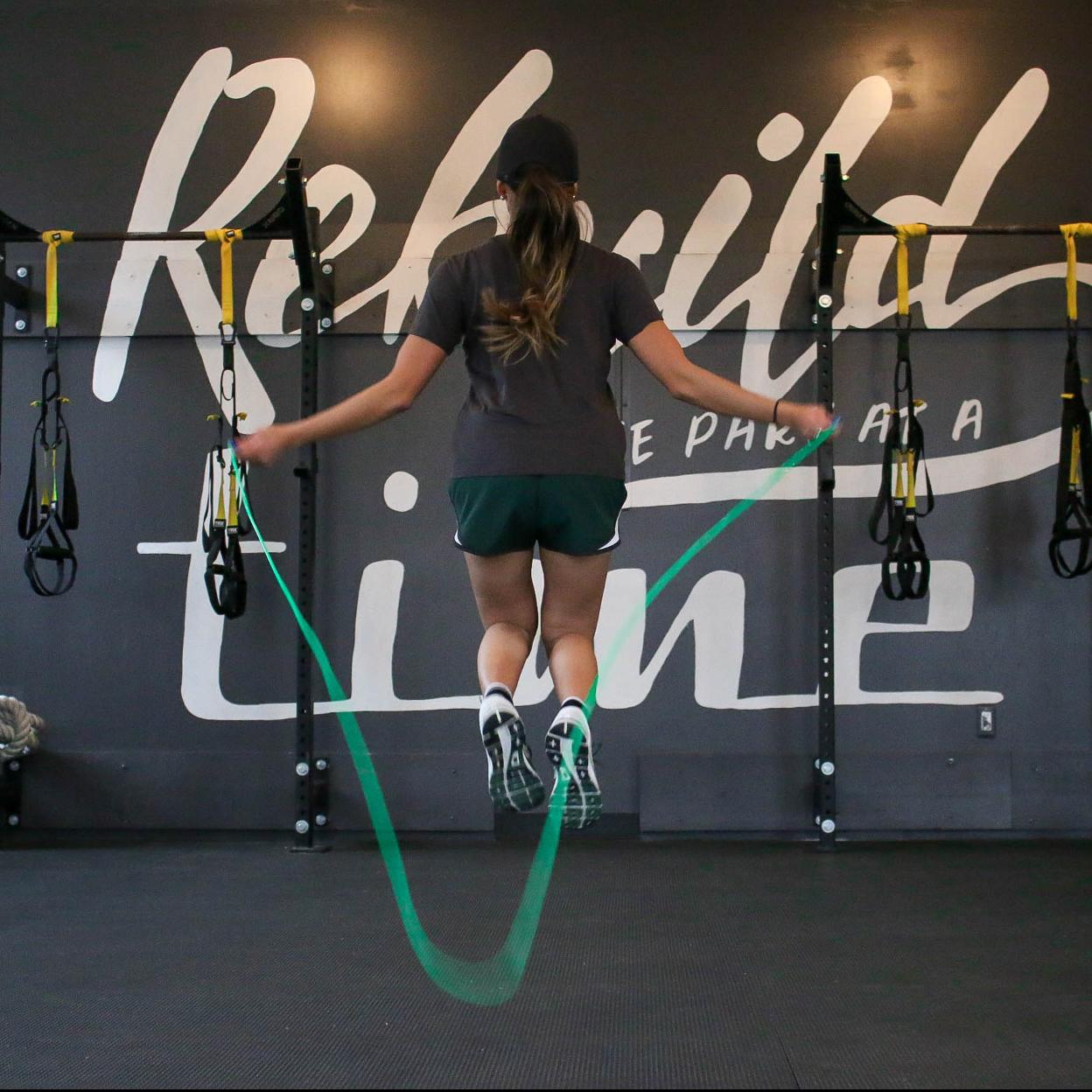 Mujer saltando a la comba en un gimnasio.
