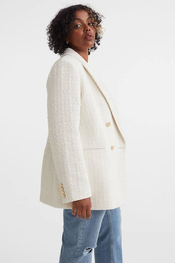 Blazer en tejido texturizado con solapas de pico, bolsillos ribeteados y cierre de doble botonadura con relieve dorada, en crema, de H&M. Su precio es de 59,99 euros.