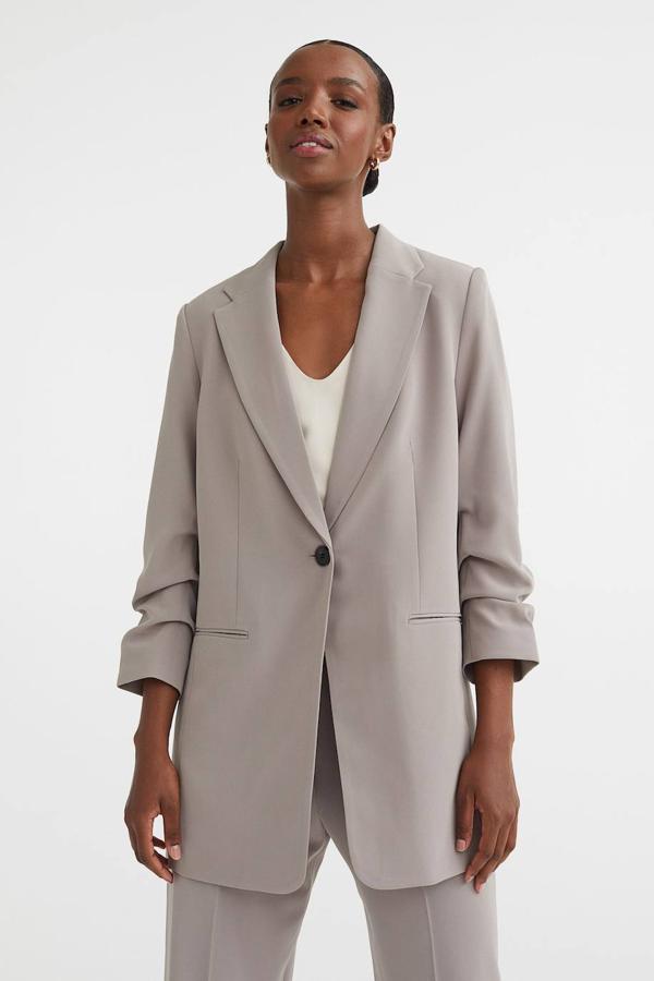 Blazer fluida con cuello solapa, bolsillos de ojal, cierre de botón y manga larga recogida, en gris, de H&M. Cuesta 39,99 euros.