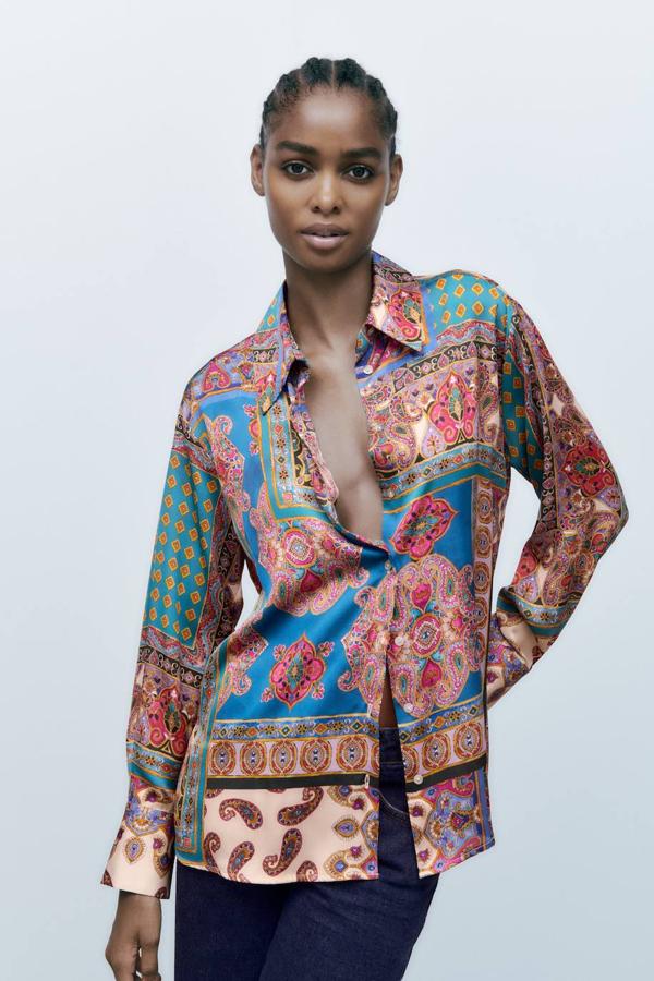 Camisa satinada y fluida con cuello solapa, manga larga, cierre de botones y estampado multicolor tipo patchwork mezcla de paisley y oriental, de Zara. La encontrarás a 25,95 euros.