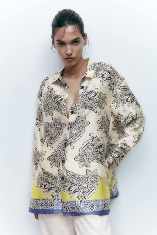 Camisa larga en tejido fluido con cuello solapa, manga larga, cierre de botones, corte amplio estampado oriental en crudo, negro, amarillo y azul, de Zara. Su precio es de 29,95 euros.
