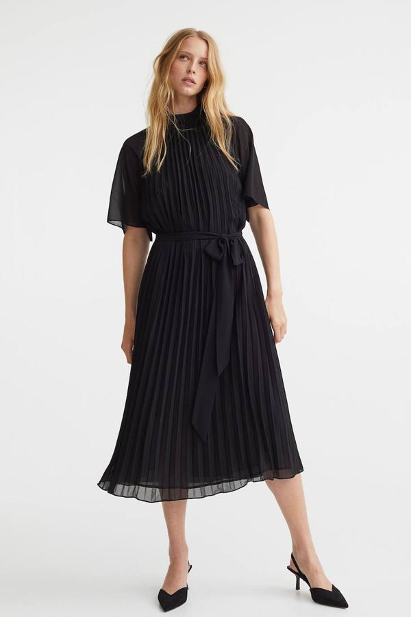 Vestido plidi plisado con mangas cortas vaporosas, cuello subido y cinturón de lazada, color negro, de H&M. Lo encontrarás a 39,99 euros.