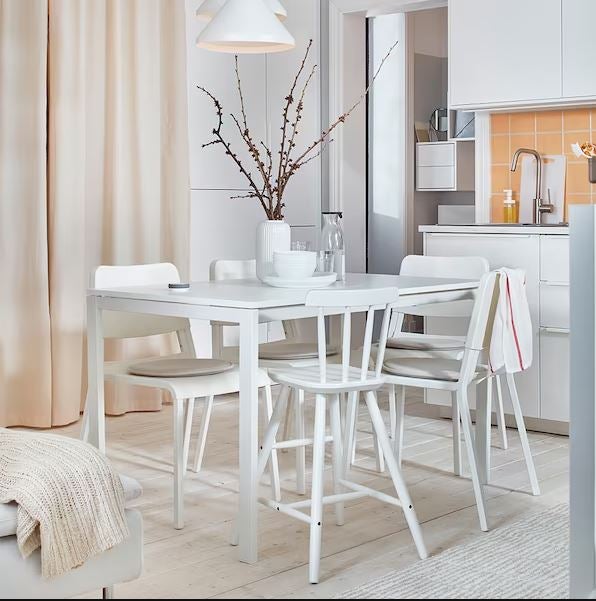 Una mesa de comedor totalmente blanca para un salón minimalista.