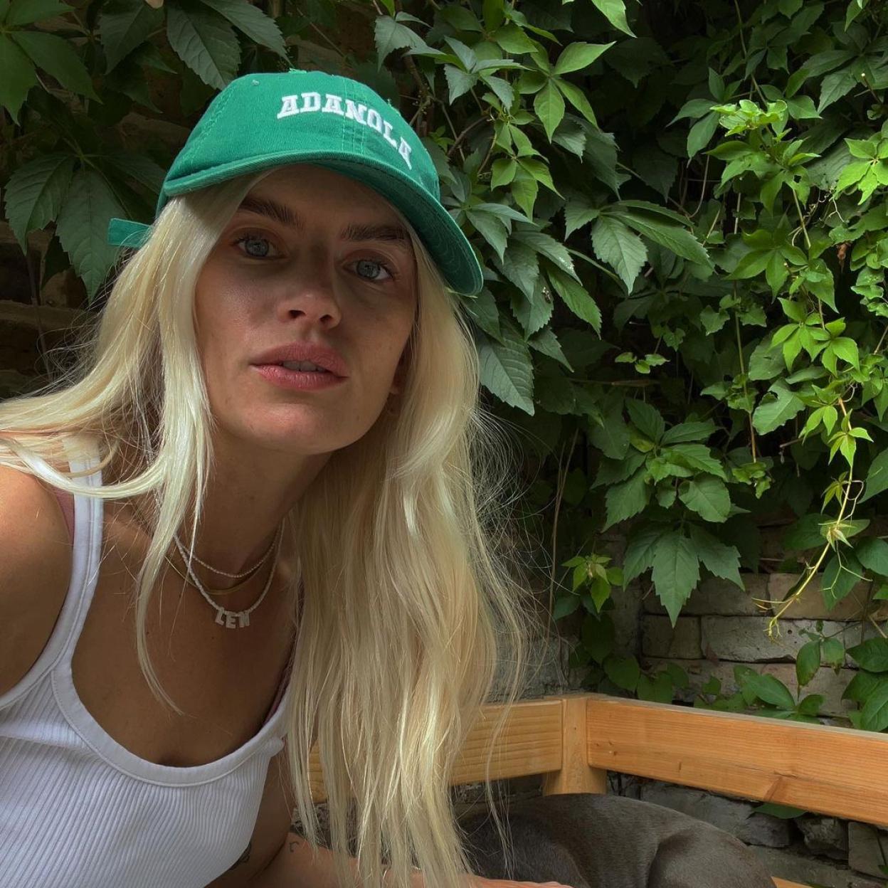 La influencer Kasia Chin con una gorra verde y una camiseta blanca. Su piel es lisa y sin imperfecciones. 