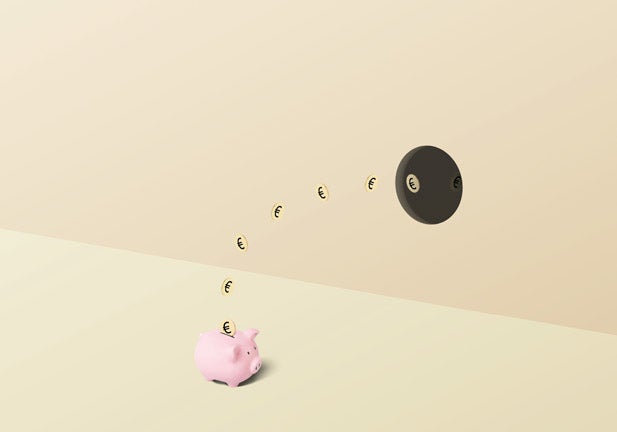 Pink piggy bank with gold euro coins falling into it from a hole in the wall on a split colored yellow golden background