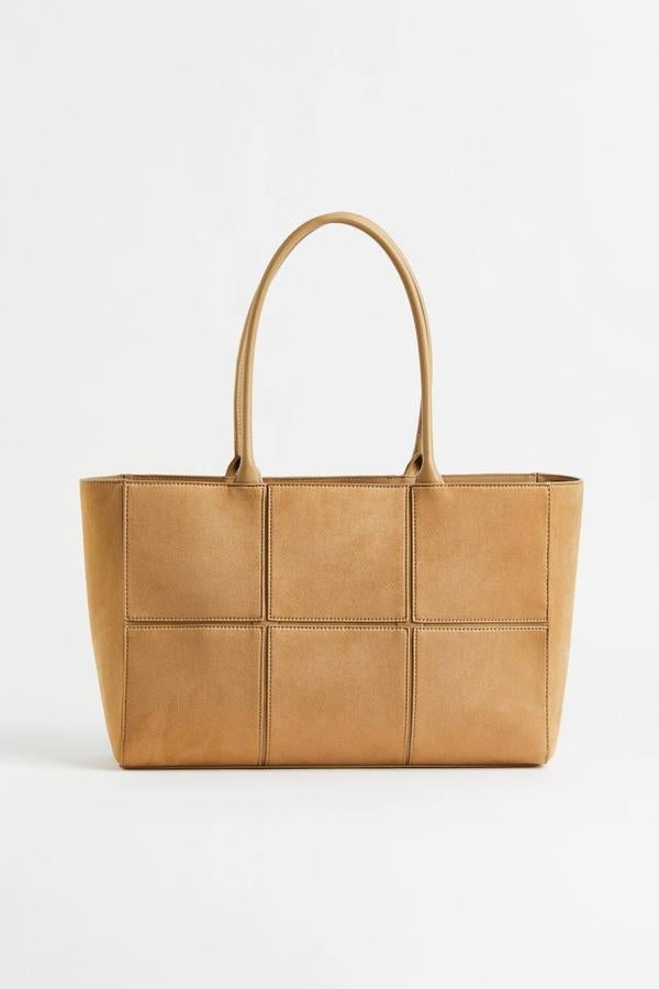 Bolso shopper en tejido de piel sintética con tacto suave, diseño de patrón a cuadros, compartimento interior con cremallera y doble asa de hombro, en beige oscuro, de H&M. Puedes encontrarlo por 29,99 euros.