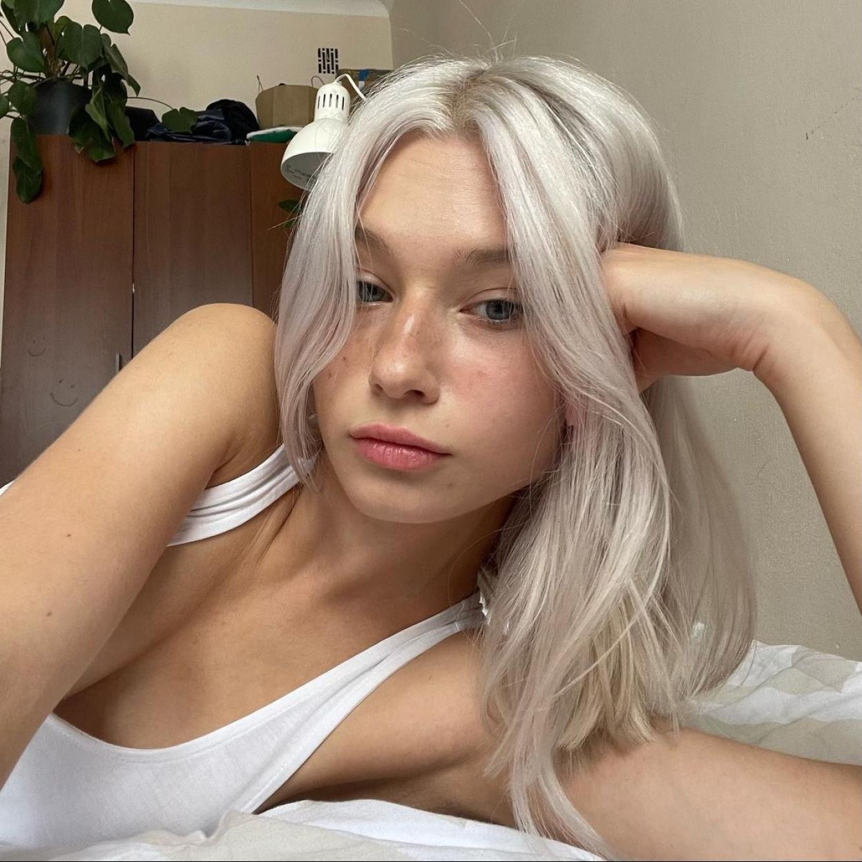 La influencer Faustyna Maciejczuk apoyada sobre un brazo sin maquillaje. 