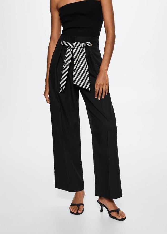 Hay pequeños detalles que pueden transformar hasta la prenda más básica. Pantalón negro con pañuelo con estampado de rayas de Mango (39,99 euros). 