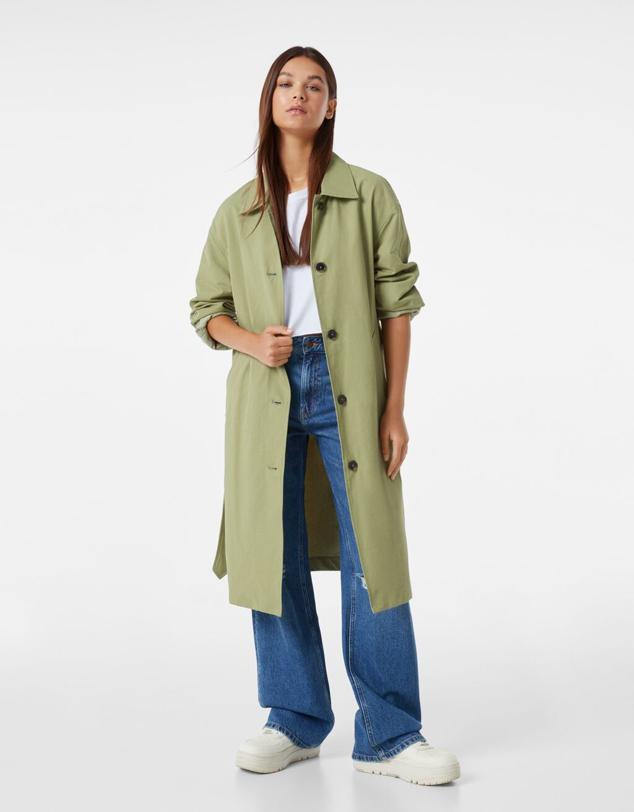 Un diseño básico, de corte recto, en un verde medio que aporta un toque de luz a los días lluviosos. Trench con cinturón de Bershka (39,99 euros). 