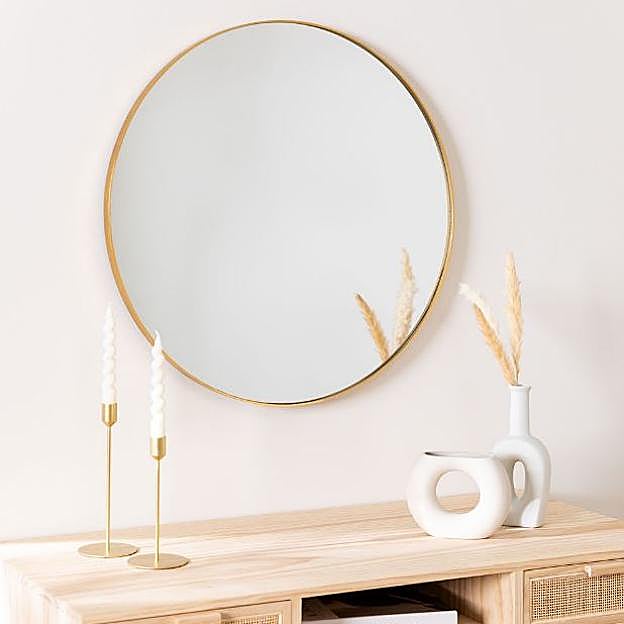 Un espejo redondo con borde metálico.