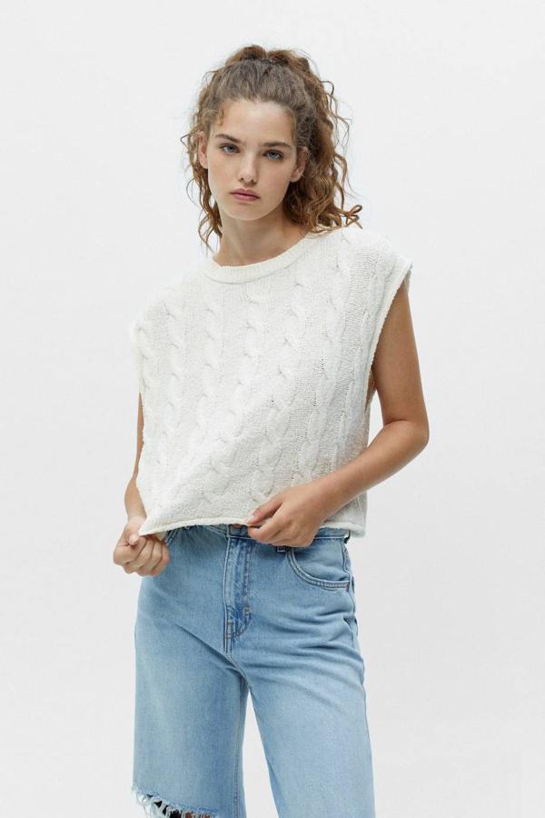 Chaleco en tejido de punto rústico con detalles trenzados, manga sisa y cuello redondo, color crudo, de Pull&Bear. Lo encontrarás a 19,99 euros.