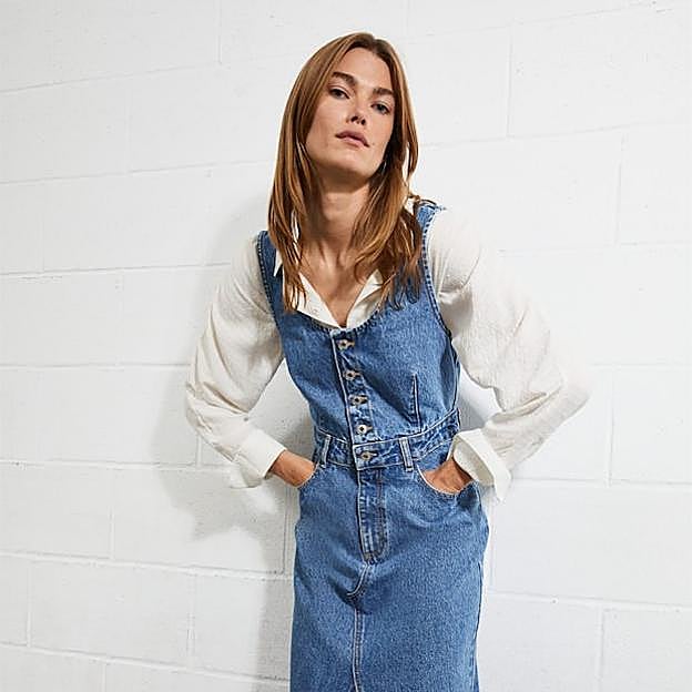 Imagen principal - El vestido vaquero más buscado del momento está en Mango. Es tipo peto, lleva botones y lo podrás estrenar ahora con tu blusa blanca preferida. Peto vaquero de Mango (39,99 euros). 