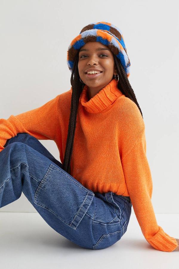 Jersey cropped de corte boxy con silueta relajada, cuello alto amplio acanalado y mangas largas, color naranja. Su coste es de 14,99 euros.