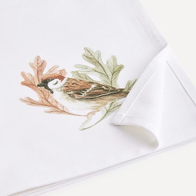 Unas servilletas muy bonitas con fondo blanco y un pájaro en un lado.