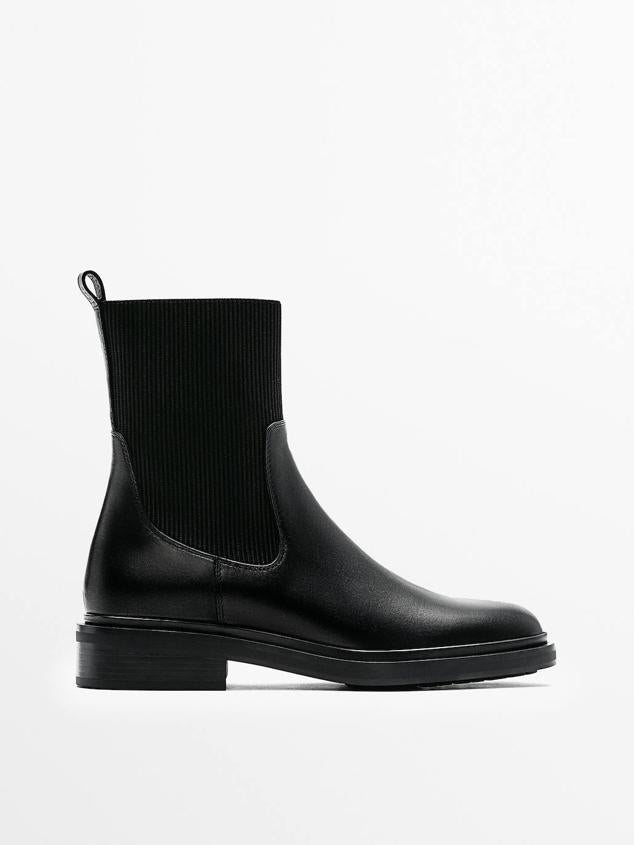 Botín tipo chelsea con suela plana, puntera redondeada y caña en tejido elástico, color negro, de Massimo Dutti. Cuesta 99,95 euros.