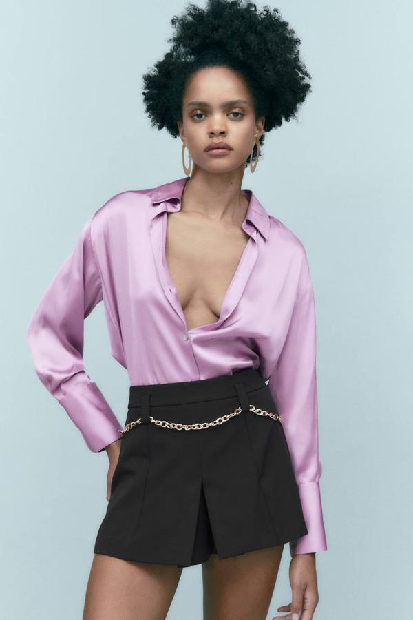Camisa satinada fluida con silueta relajada, manga larga recogida en puño ancho, cuello solapa y cierre de botones, en lila, de Zara. Está disponible por 19,95 euros.