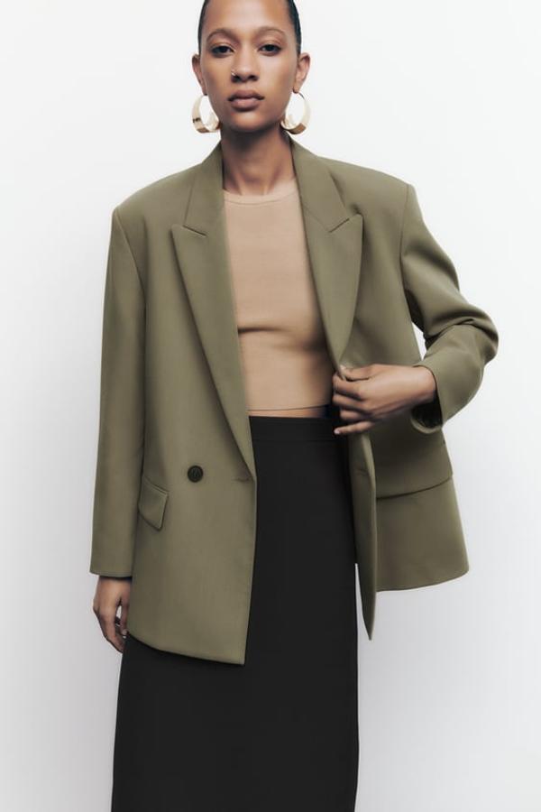 Blazer amplia de cuello y solapa con manga larga y hombros marcados. Bolsillos delanteros con solapa y cierre frontal cruzado con botones. Está disponible en dos colores, kaki y negro. Precio: 39,95 euros.