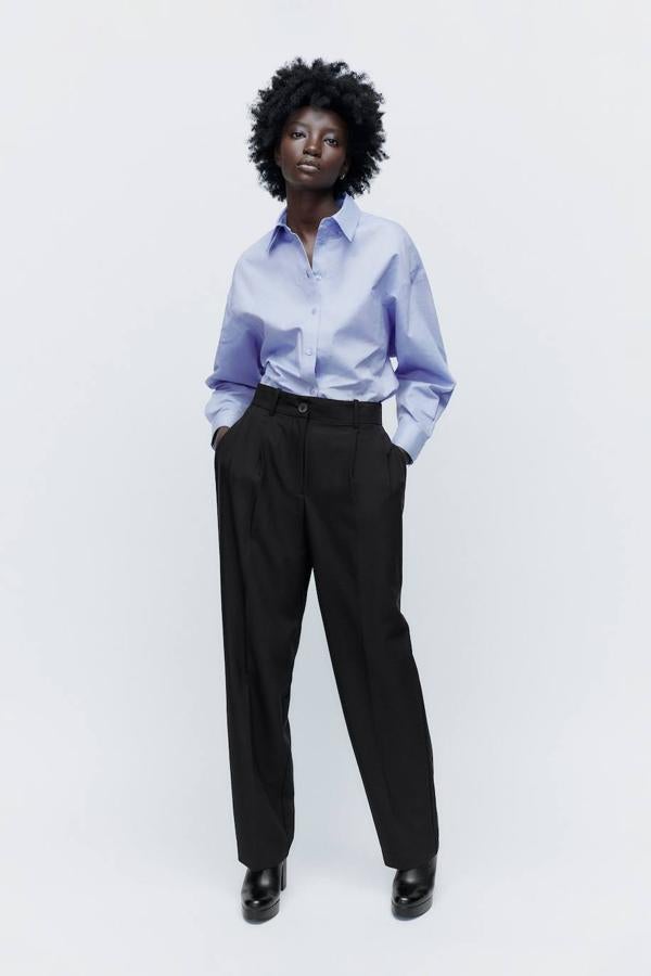 Pantalón largo de estilo masculino con perneras rectas y amplias, raya marcada, detalles de pinzas, bolsillos y tiro alto, color negro, de Zara. Puedes comprarlo a 29,95 euros.