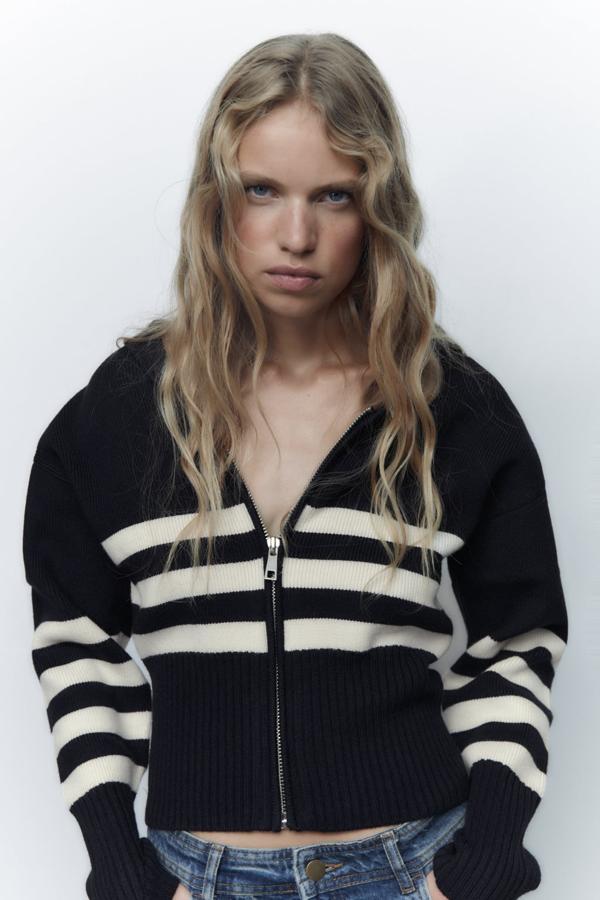 Una versión más informal de esta prenda de punto, por obra y gracia de una simple cremallera. Cahqueta negra con rayas blancas de Zara (29,99 euros). 