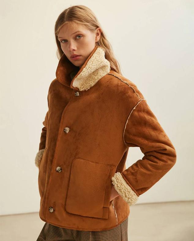 Chaqueta de doble faz con exterior en efecto piel suave e interior de borreguillo, cuello solapa, bolsillos laterales, manga larga y cierre de botones, en marrón y beige, de Sfera. Cuesta 49,99 euros.