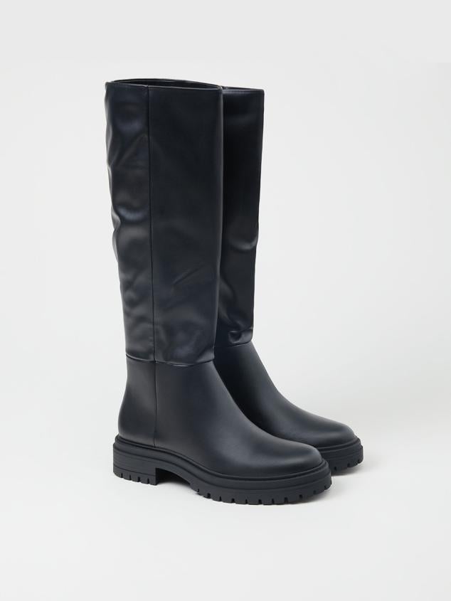 Botas altas de caña con suela plana para poder soportar las largas horas en la oficina. Son de Lefties. Precio: 35,99 €.