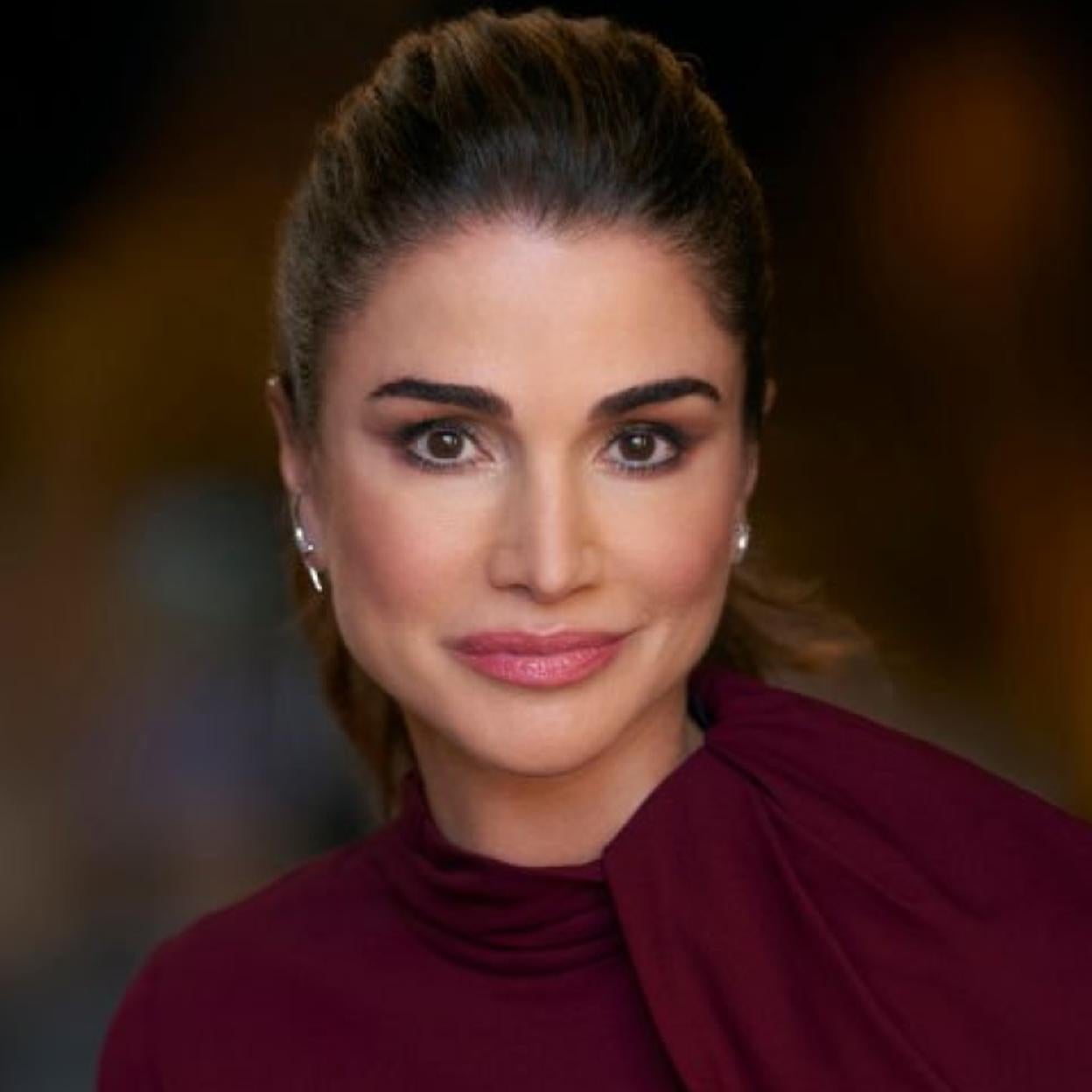 La reina Rania de Jordania vestida de granate. 