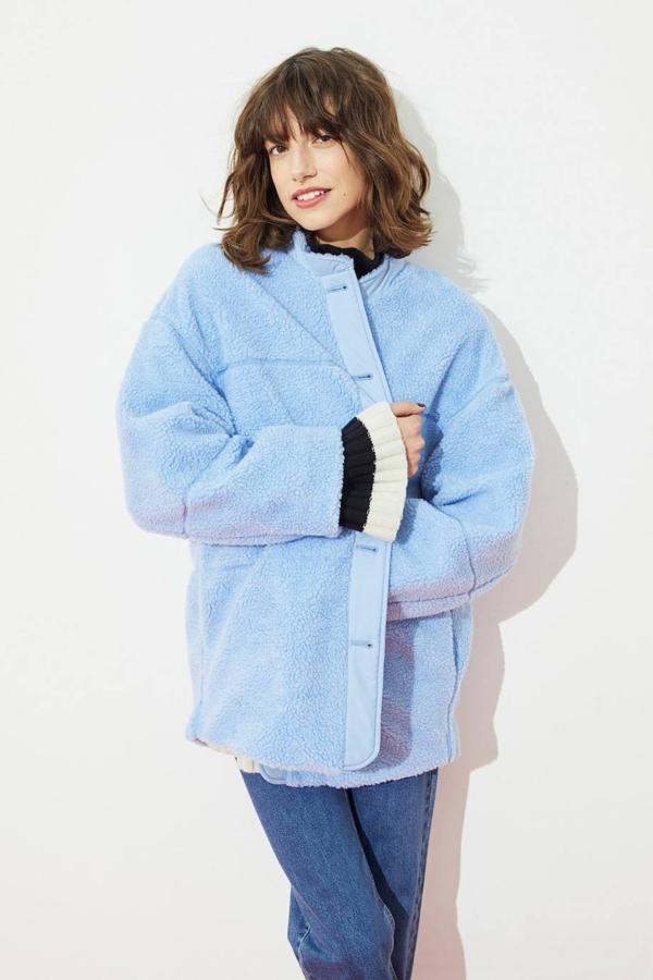 Chaqueta oversize de borreguillo con manga larga, cuello redondo y cierre de botones delantero, en azul claro, de H&M. Puedes encontrarla por 49,99 euros.