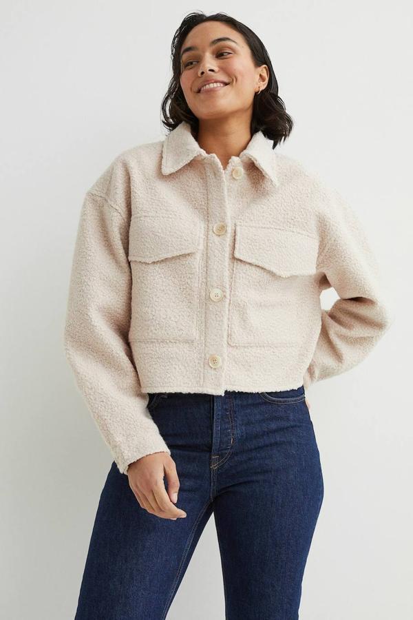 Chaqueta cropped en tejido de borreguillo con cuello solapa, manga larga, cierre de botones a tono y bolsillos delanteros con tapeta, color beige claro, de H&M. Su precio es de 29,99 euros.