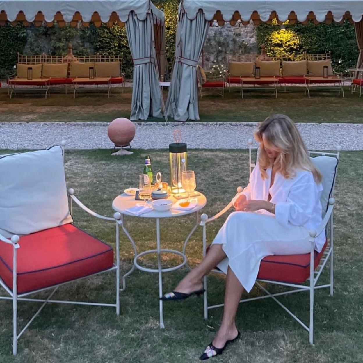 La influencer lleva un vestido blanco tipo camisero y unas balerinas negras.