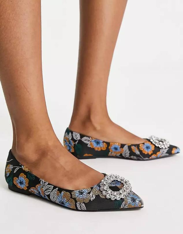 Bailarinas en tejido jacquard con flores metalizadas, escote redondo, terminación en punta y hebilla enjoyada, de Asos. Tiene un coste de 28,99 euros. Cómpralo aquí