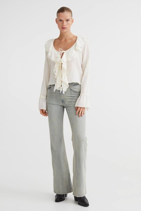 Vaqueros bootcut confeccionados en algodón grueso con tiro bajo, perneras ajustadas y ligeramente acampanadas, trabillas para el cinturón y cinco bolsillos, color azul denim con beige desgastado, de H&M. Su precio es de 39,99 euros.