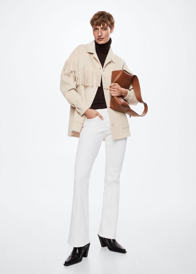 Pantalón vaquero en tejido elástico con pernera ajustada y acampanada, tiro medio, trabillas para el cinturón y cinco bolsillos, color blanco, de Mango. Cuestan 19,99 euros.