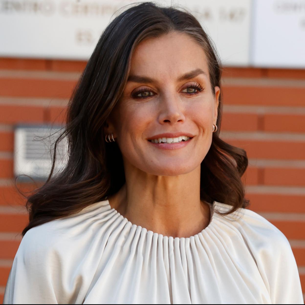 La reina Letizia con una blusa blanca.