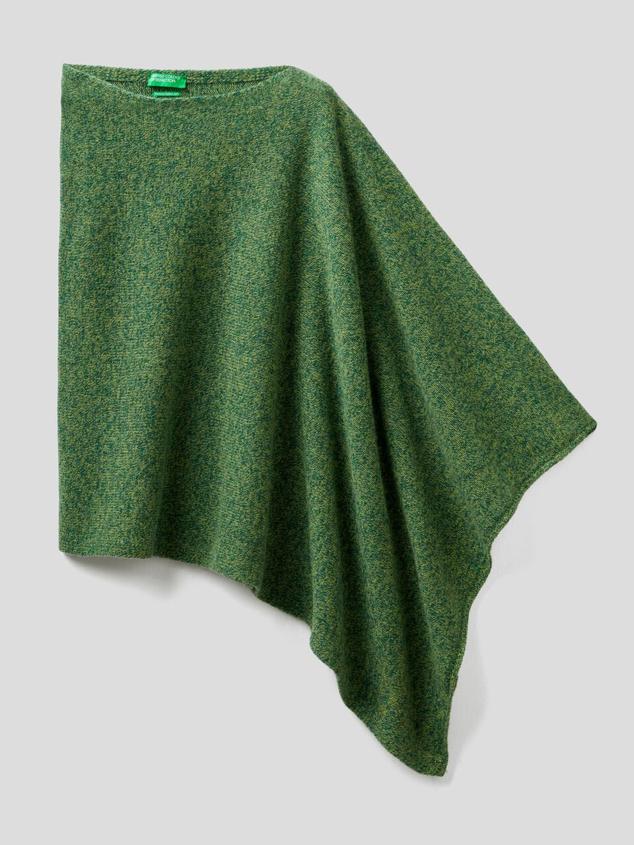 Poncho de escote amplio redondeado confeccionado mediante hilo italiano. Podrás encontrarlo de múltiples colores. Es de Benetton. Precio: 59,95 €. Cómpralo aquí
