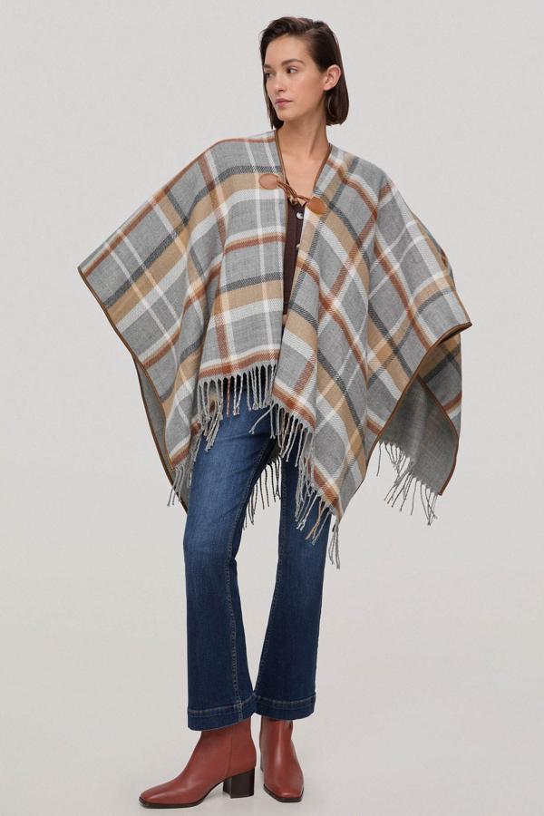 Poncho ribeteado con estampado de cuadros de colores básicos otoñales para combinar con casi cualquier prenda de tu armario. Es de Pedro del Hierro. Precio: 79,90 €. Cómpralo aquí