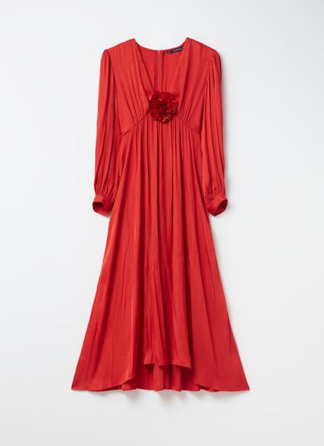 Imagen - El vestido lleva una flor en el escote.