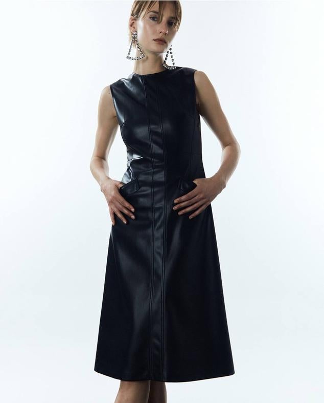 Vestido midi en tejido efecto piel con cuello redondo, manga sisa y bajo acabado en evasé, color negro, de Sfera. Tiene un coste de 39,99 euros.