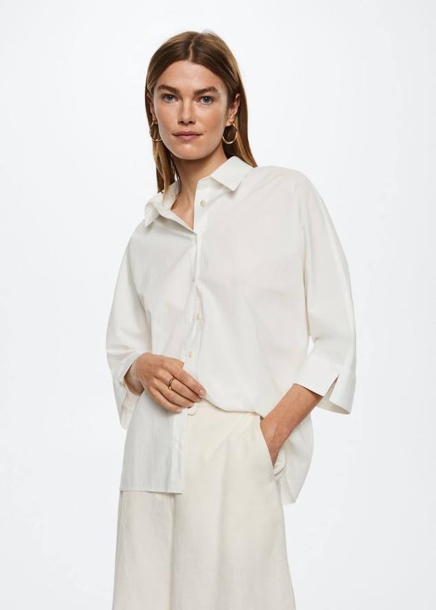Camisa blanca 100% algodón con diseño oversize, cuello solapa, manga tres cuartos tipo murciélago y abertura en los puños, de Mango. La encontrarás a 25,99 euros.