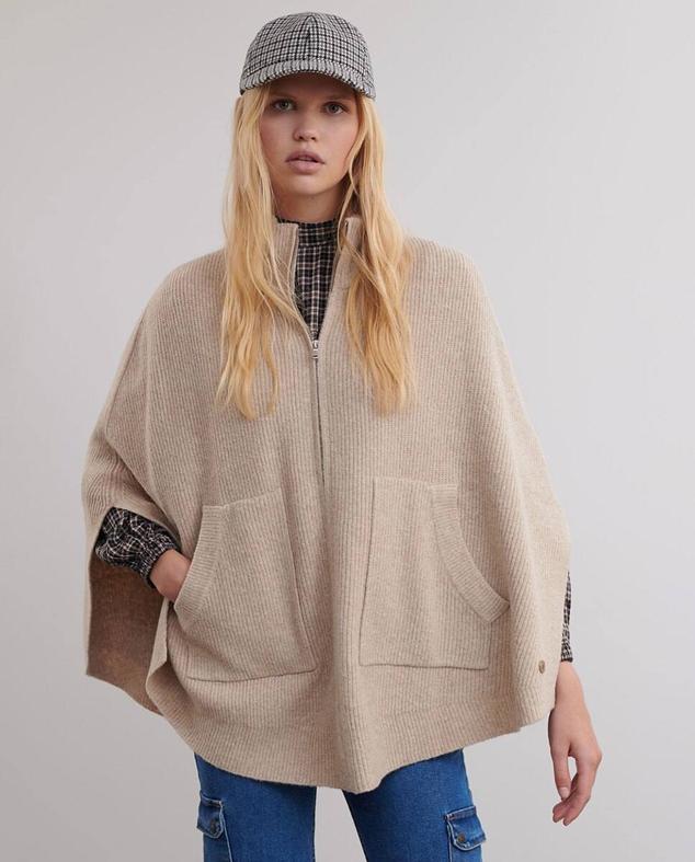 Capa en tejido de punto acanalado con silueta relajada, aberturas laterales, cuello alto, bolsillos y cierre de cremallera, color beige, de Brownie. Está disponible a 59,90 euros. Cómpralo aquí