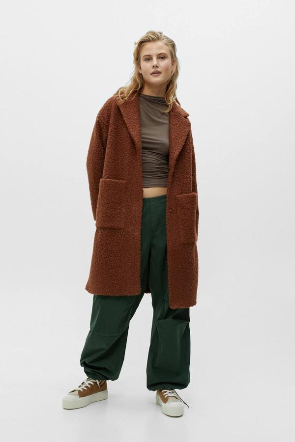 Abrigo de pelo rizado con cuello solapa con muesca, manga larga, bolsillos de plastrón y cierre sencillo mediante botón, en marrón, de Pull&Bear. Hazte con él por 39,99 euros.