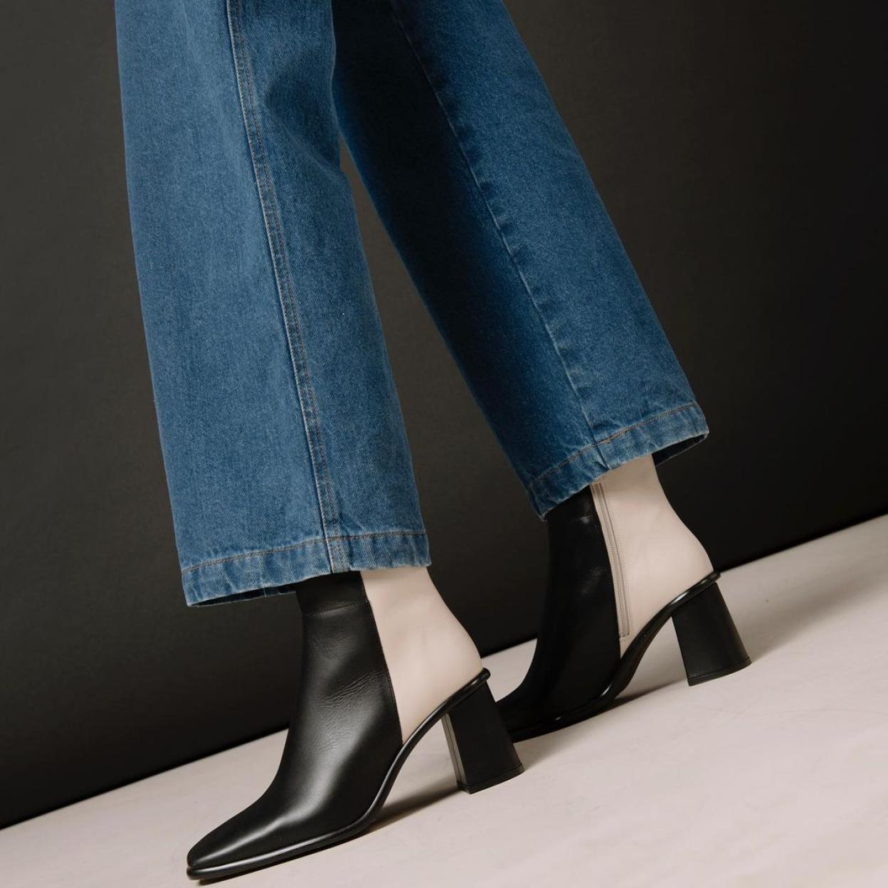 Un estilismo que combina unos vaqueros tipo flare con unos botines de piel blanco y negros.