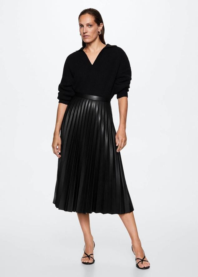 Falda midi confeccionada en tejido efecto piel con diseño plisado, bajo acabado en evasé y talle alto, color negro, de Mango. La comprarás a 45,99 euros.