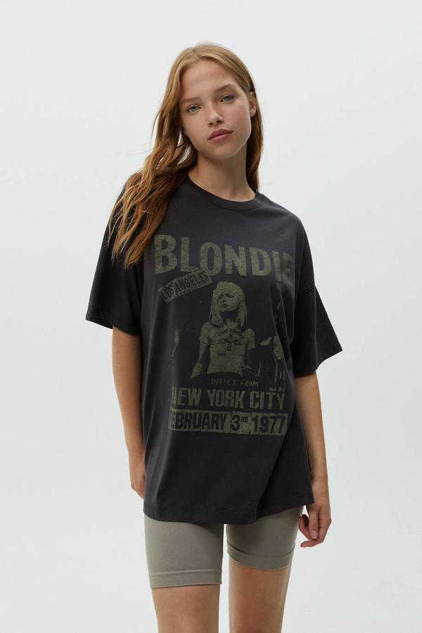 Camiseta oversize de manga corta con cuello redondo y estampado de grupo musical, color gris oscuro, de Pull&Bear. Cómprala por 17,99 euros.