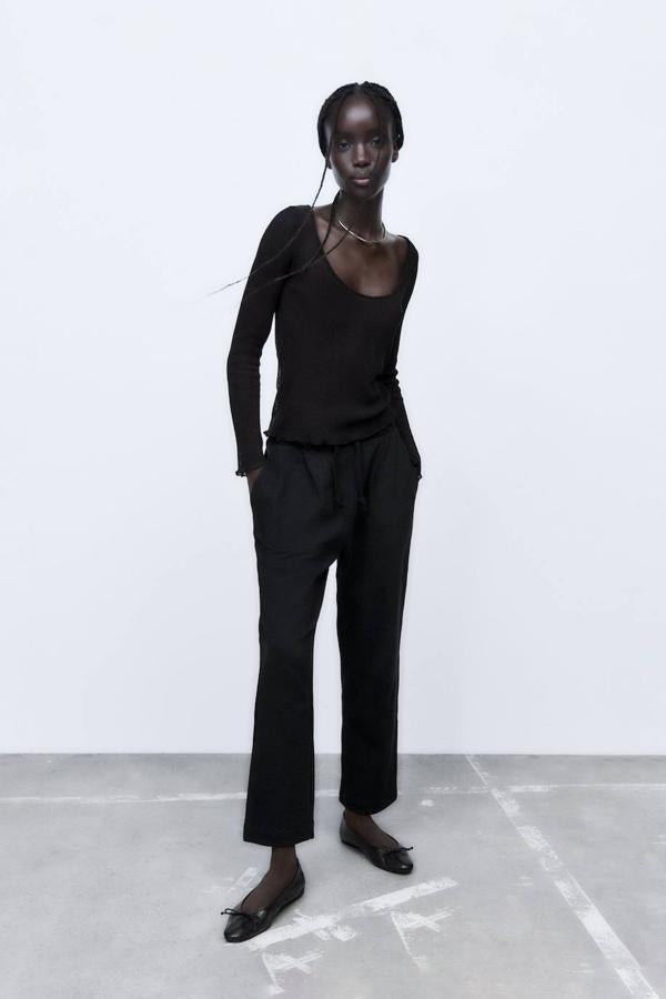 Pantalón jogger relaxed fit con cintura elástica ajustable mediante cordones, bolsillos y detalles de pinzas, en negro, de Zara. Su precio es de 19,95 euros.