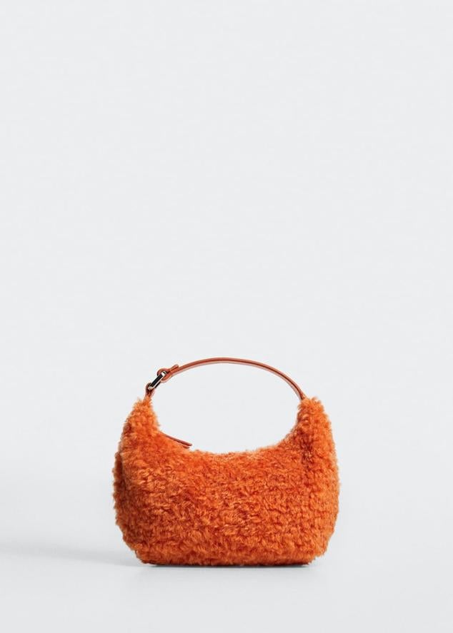 Si quieres hacerte con un accesorio realmente original, no dejes escapar este bolso de asa corta. Bolso de pelo naranja de Mango (29,99 euros). 