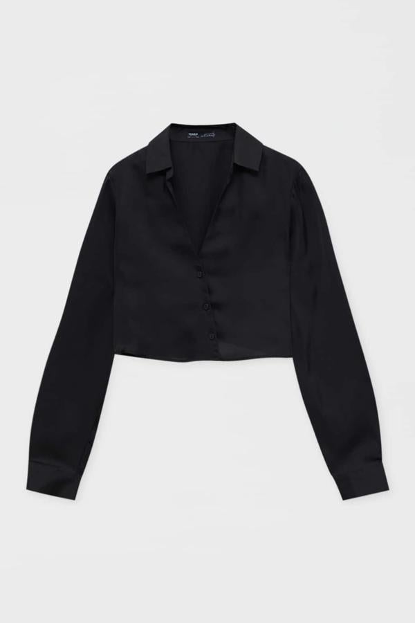 Camisa cruzada satinada y de corte crop. Podrás crear estilismos extrovertidos con minifalda y botas altas. Es de Pull & Bear. Precio: 19,99 €.