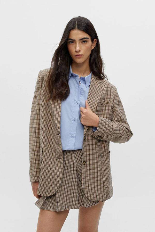 Blazer estilo college con cuello solapa con muesca, tres bolsillos, manga larga, diseño estructurado, cierre mediante botón y estampado de cuadros, de Pull&Bear. Está disponible por 35,99 euros.