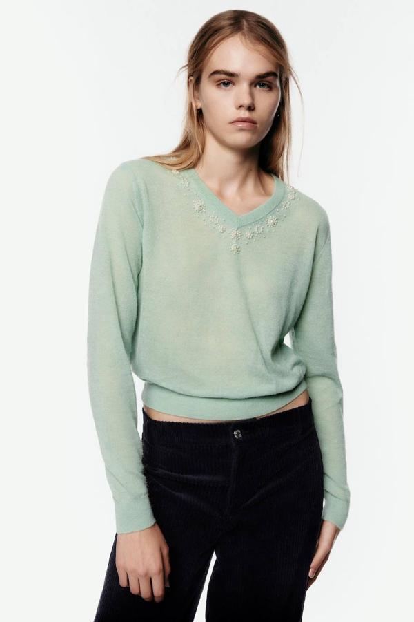Jersey de punto fino con cuello de pico, manga larga y decoración de perlas, color verde claro. Su coste es de 29,95 euros.