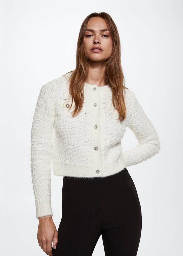 Cárdigan en tejido de punto grueso estructura con manga larga, cuello redondo, corte acomodado al cuerpo y cierre de botones joya, color blanco, de Mango. Cuesta 39,99 euros.