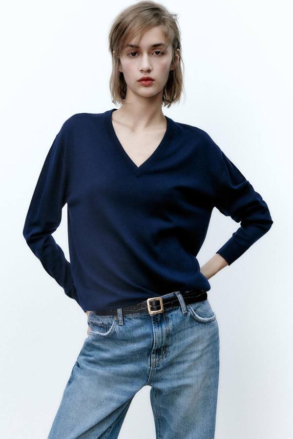 Jersey en tejido de punto 100% lana fina con corte acomodado al cuerpo, manga larga y escote de pico, azul marino, de Zara. Puedes comprarlo a 39,95 euros.